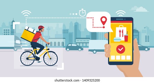 Food Delivery App On A Smartphone Tracking A Delivery Man On A Bicycle Carrying A Ready Meal, Technology And Logistics Concept, City Skyline In The Background