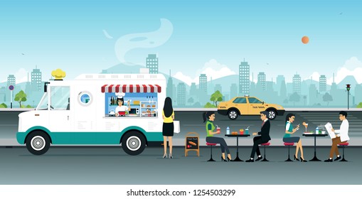 Food trucks sell to people sitting on the street.