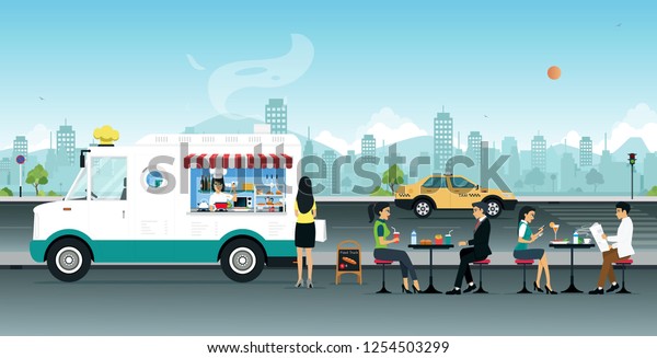 Food trucks\
sell to people sitting on the\
street.