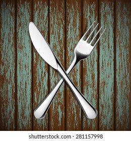 Fork and knife lying on a wooden table. Vector Image.