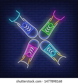 Four feet standing in circle neon sign. Friendship, unity, advertisement design. Night bright neon sign, colorful billboard, light banner. Vector illustration in neon style.