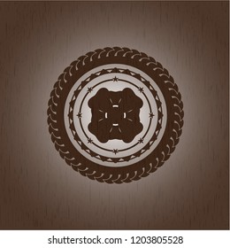 four leaf clover icon inside badge with wood background