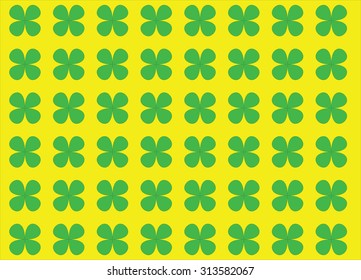 Four leaves green clovers aranged on yellow background