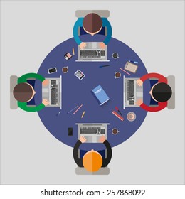Four office workers sitting at the round table 