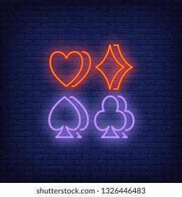 Four suit symbols neon sign. Gambling and poker club design. Night bright neon sign, colorful billboard, light banner. Vector illustration in neon style.