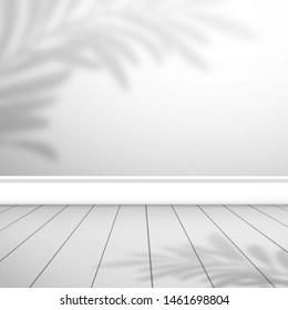 Fragmento de una habitación vacía con una pared blanca y tablas de suelo. La hoja de palma de la sombra está en la parte superior. Fondo para el diseño