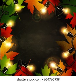 Frame of autumn leaves painted on black chalkboard