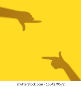Frame focus Shadows of female hands. Isolated on yellow background.