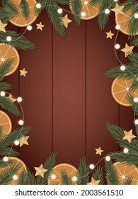Frame made of spruce branches, oranges and garlands on a wooden background. 