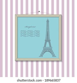 Framed picture with eiffel tower in vintage style on striped wallpaper. 