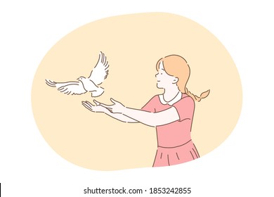 Freedom, peace, harmony, release, kindness concept. Young kind smiling girl cartoon character in dress standing and letting white pigeon dove bird fly from hands in park outdoor releasing letting go