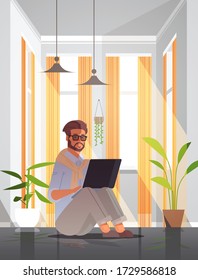 autónomo de uso de portátil hombre que trabaja desde el autoaislamiento del hogar coronavirus pandemia concepto de cuarentena de sala de estar moderna interior de longitud completa ilustración vectorial vertical