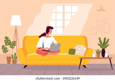 A freelancer woman is sitting on the couch and working on a laptop. The girl studies at home. Home office concept