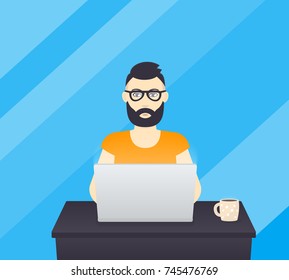 freelancer working at laptop, bearded man wearing glasses at work