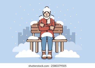 Freezing man sits on bench covered with snow due to lack of home and homeless shelters. Freezing guy is shaking and experiencing chills and needs social assistance to avoid getting sick.