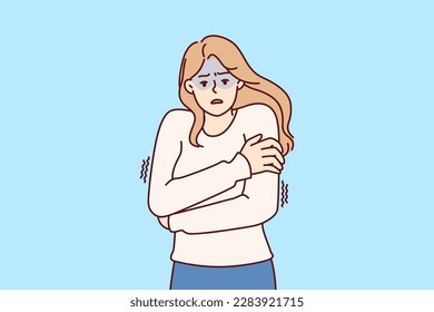 Freezing woman hugging shoulders trying to keep warm and feeling chills after contracting flu infection or fever. Freezing girl in sweater dreams of warm house to wait out cold weather 