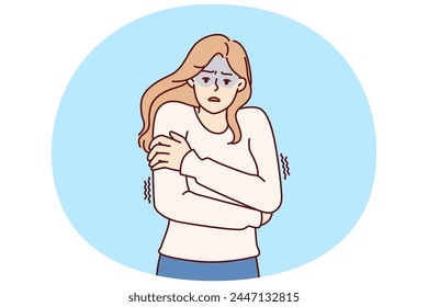 Freezing woman hugging shoulders trying to keep warm and feeling chills after contracting flu infection or fever. Freezing girl in sweater dreams of warm house to wait out cold weather