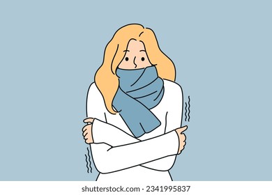 Freezing woman with scarf around neck is shivering from cold and needs warm clothes or climate equipment. Freezing girl suffers from sudden change in temperature and onset of winter