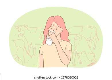 Fresh cow farm milk concept. Small girl standing and drinking fresh organic dairy milk from glass or bottle on farm with eating cows at background. Healthy drink for children 