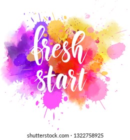 Fresh start - motivational message. Handwritten modern calligraphy message on multicolored watercolor paint splash.