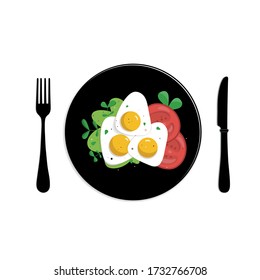Fried eggs with tomatoes and herbs on a black plate with black appliances.