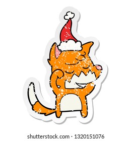 friendly hand drawn distressed sticker cartoon of a fox waking up wearing santa hat