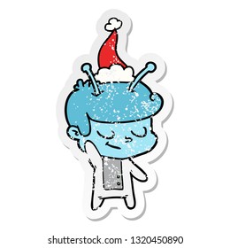 friendly hand drawn distressed sticker cartoon of a spaceman wearing santa hat