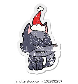 friendly hand drawn distressed sticker cartoon of a wolf sitting wearing santa hat