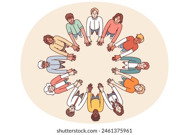 Friendly people stand in circle hold hands for collaboration and teamwork, top view. University students of different gender and race get education together while studying in college