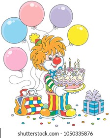 Friendly smiling circus clown in a colorful suit with a birthday cake, balloons and a gift