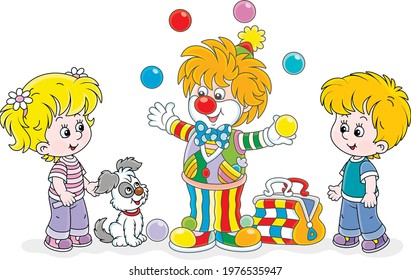 Friendly smiling circus clown showing trick and juggling with colorful balls for little kids and their small pup, vector cartoon illustration isolated on a white background