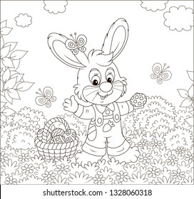 Friendly smiling Easter Bunny with a basket of painted eggs among flowers on sunny spring day, black and white vector illustration in a cartoon style for a coloring book