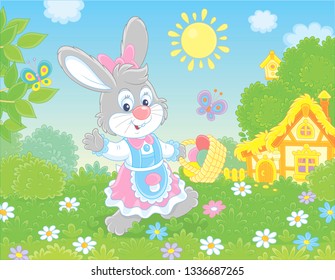 Friendly smiling Easter Bunny with a basket of colored eggs walking in front of a small hut among flowers on green grass on sunny spring day, vector illustration in a cartoon style