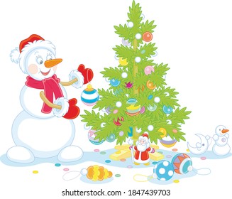 Friendly smiling snowman with a red hat, a warm scarf and mittens decorating a prickly green Christmas tree with colorful balls, garlands and toys, vector cartoon illustration