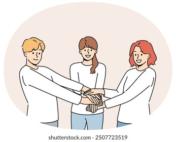 Friendly team of people holding hands demonstrate cohesion and unity, wanting to achieve goals together. Team of young guy and two girls carrying out volunteer or charitable activities