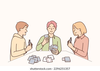 Amigos jugando cartas sentados en la mesa disfrutando juntos del juego de póquer con compañeros de trabajo o compañeros de universidad. Mujer y dos hombres jugando relajándose el viernes por la noche en una fiesta de póquer