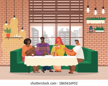 Friends are sitting on soft long green sofa in cafe or restaurant with loft interior style at a table eating and drinking. Cheerful company of people in the club having fun, talking, communicating
