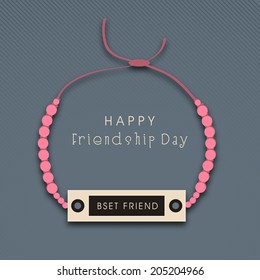 Friendship band with pink pearls on grey background for Happy Friendship Day celebrations. 