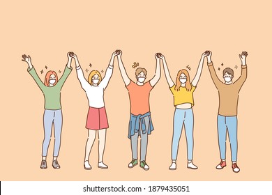 Friendship and having fun during COVID-19 pandemic concept. Group of young positive friends in protective medical face masks standing and holding raised hands in team during pandemic illustration 