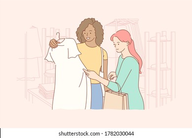 Friendship, shopping, recreation, fashion, beauty concept. Young woman and african american girl friends customers choosing swapping trendy clothes at shop. Consumption and stuff exchage buying dress.