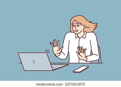 Frightened businesswoman sitting at table and looking at laptop after seeing cash gap notice in own company. Shocked businesswoman after error or notification about presence of viruses in computer 