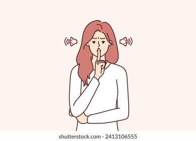 Frowning woman makes tss gesture calling for phones to be turned off or to speak more quietly. Girl orders silence, showing tss sign with hand, to calm down hyperactive children making lot of noise.