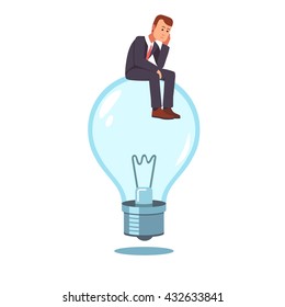 Frustrated businessman sitting on a not lit idea light bulb hatching an idea. Business thinking metaphor. Flat style vector illustration clipart.