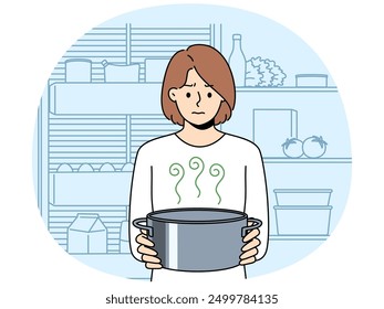 Frustrated woman housewife with pot of sour soup, feels bad smell from food spoiled due to violation of sanitary rules. Girl is standing in kitchen and holding stinking soup in bewilderment