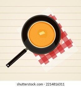 Frying pan with pancakes on white wooden table with red fringed checkered napkin