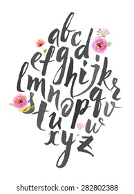 Full alphabet. Hand drawn alphabet written with brush pen. Letters are decorated with watercolor flowers. 