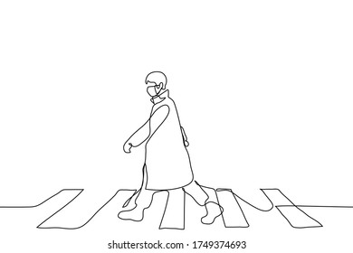 The full length figure of a man in mask dressed in a cloak and walking along a pedestrian crossing. A man alone walks at a wide pace, waving his arms wide. Can be used for animation.