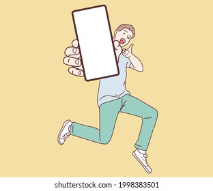 Full length portrait on joyful man jumping and showing smartphone with empty space for mobile app on white screen. 