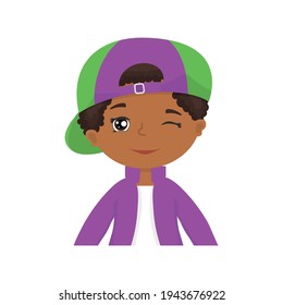 Funny african american boy in a baseball cap tucked back on his forehead, winks