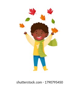 Funny African American Boy Character in Rubber Boots and Scarf Throwing Autumn Leaves Vector Illustration